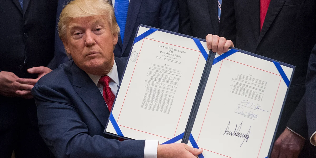 Den Donald Trump hält een ënnerschriwwenrt Dekret an d'Luucht (2017) | © picture alliance / Molly Riley/Consolidated/Pool/dpa | Molly Riley