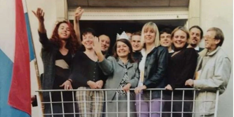 De ganzen Dag am Asaz: D‘Redaktiounsekipp vum Radio 100,7 um Dag vum Trounwiessel um Balcon vun de Lokaler vum Radio op der Lonkecher Strooss. V.l.n.r.: Monique Kater, Anne Heniqui, Marc Linster, Carole Schimmer, Serge Kesseler, Sophie Morang, Ingo Dumlich, Françoise Medernach, Gilles Wünsch, Fränz Sales  | © Archives Sophie Morang & Carole Schimmer 