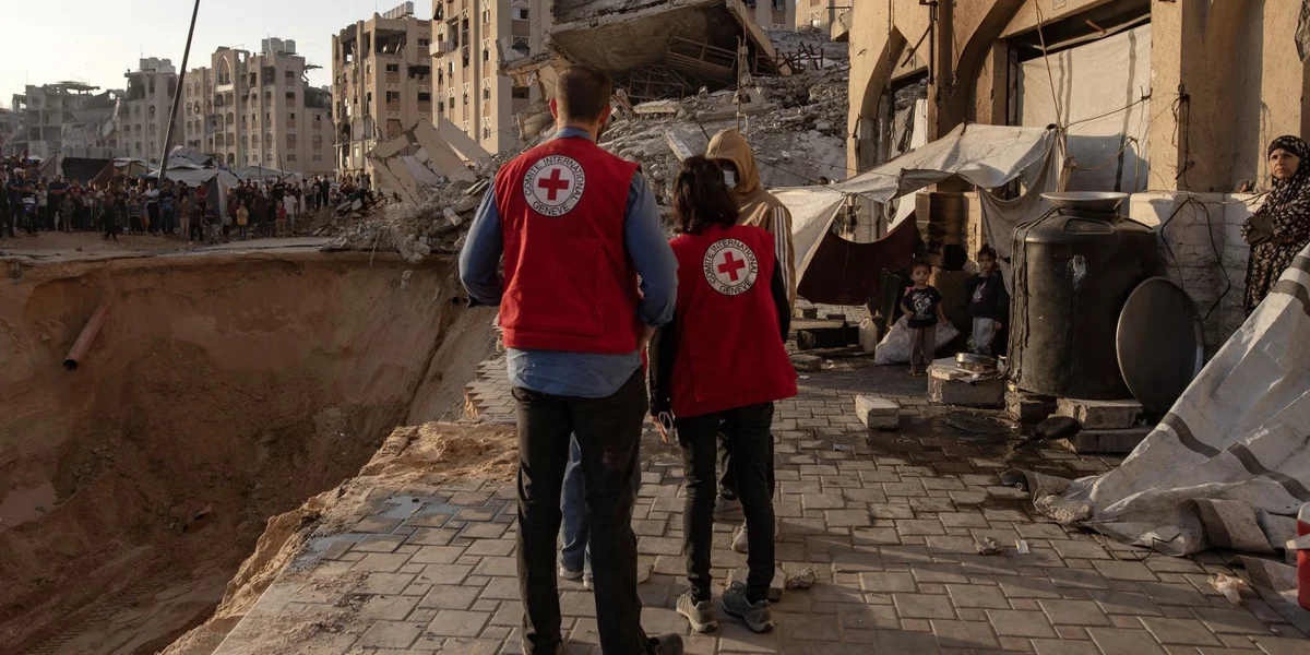 Mataarbechter:inne vum Roude Kräiz kommen do u wou Memberen vun der Al-Qassam Brigarde (dem militäreschen Deel vun der Hamas) no de Läichen vun den israeelesche Geisele sichen, Hamad Stad, Khan Younis de 17. Oktober 2025 | © EPA/HAITHAM IMAD